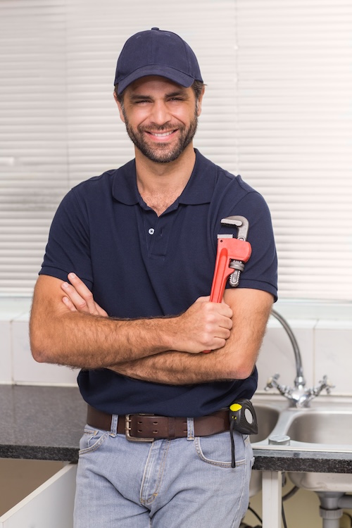 plumber smiling at the camera in the kitchen